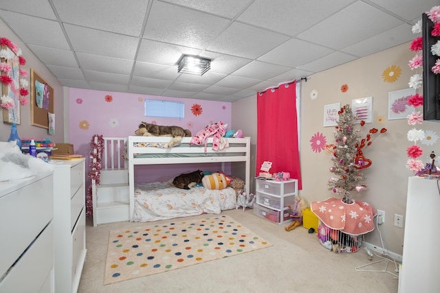 carpeted bedroom featuring a drop ceiling