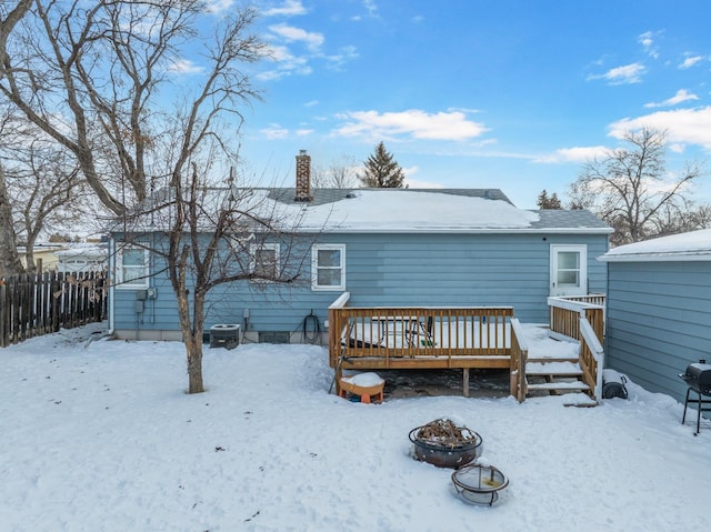 snow covered property featuring a wooden deck, central AC unit, and a fire pit