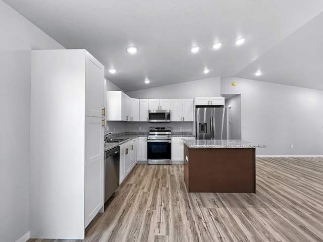 kitchen featuring sink, white cabinetry, stainless steel appliances, a center island, and light stone counters