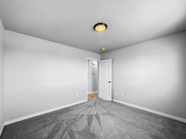 unfurnished room featuring carpet flooring and a textured ceiling