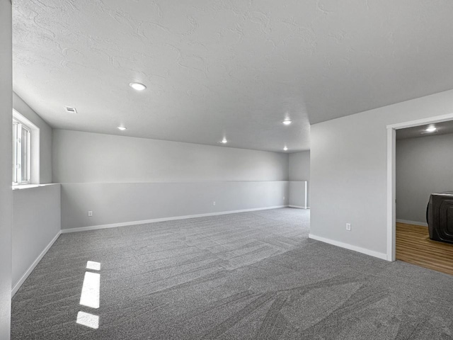 carpeted spare room with a textured ceiling