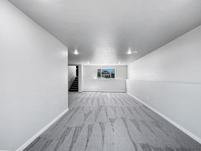 unfurnished living room featuring carpet floors and a textured ceiling