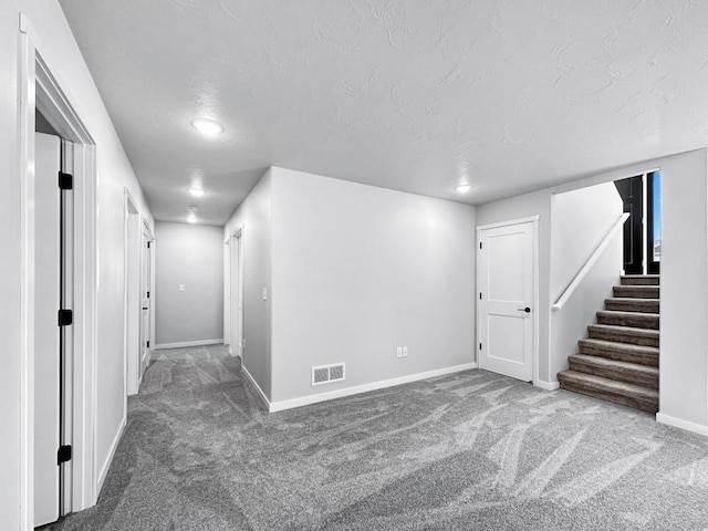 basement featuring a textured ceiling and carpet flooring