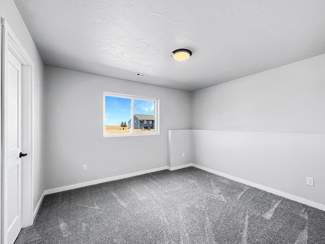 carpeted empty room featuring a textured ceiling