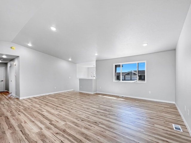 unfurnished living room with lofted ceiling and light hardwood / wood-style floors