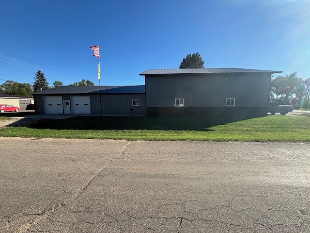 view of side of property with a garage and a lawn