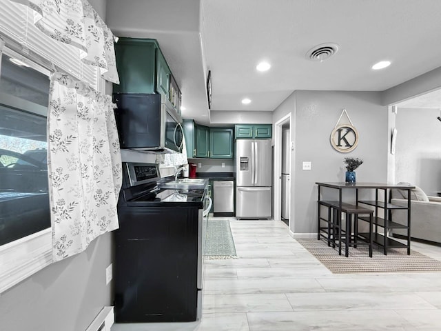 kitchen with appliances with stainless steel finishes and green cabinets