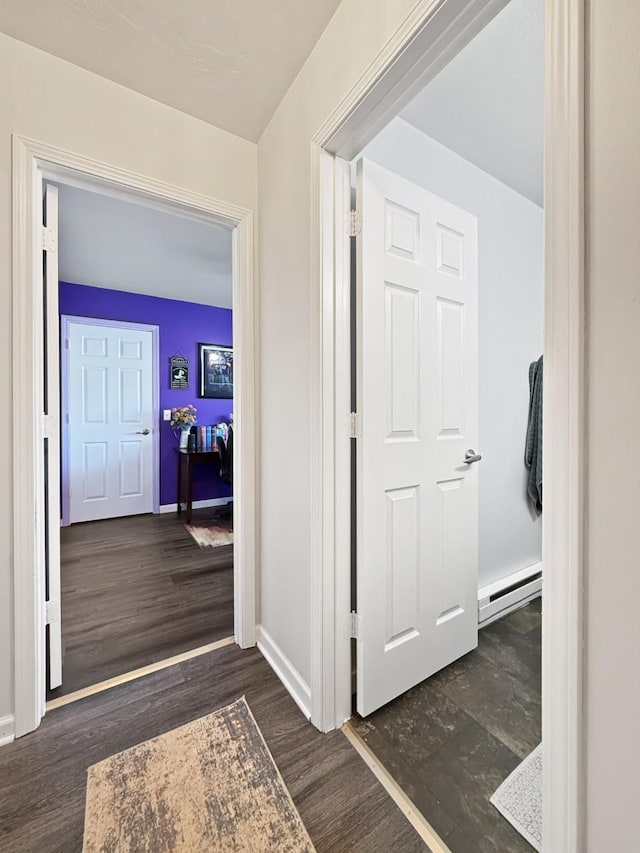 corridor with dark hardwood / wood-style flooring and a baseboard radiator