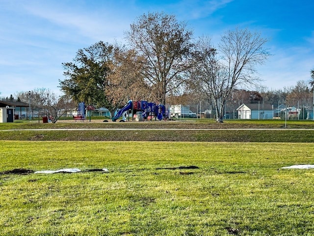 view of home's community featuring a playground and a yard