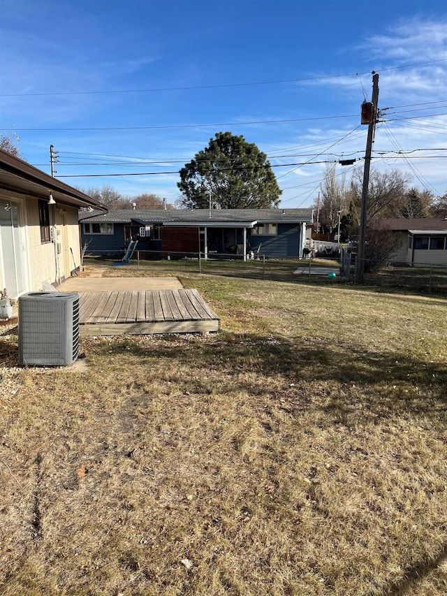 view of yard with central AC and a wooden deck