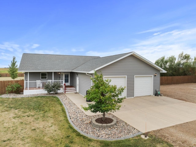 single story home with covered porch, fence, driveway, and an attached garage