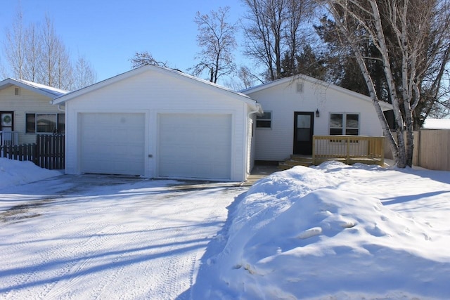 ranch-style house featuring an attached garage and fence