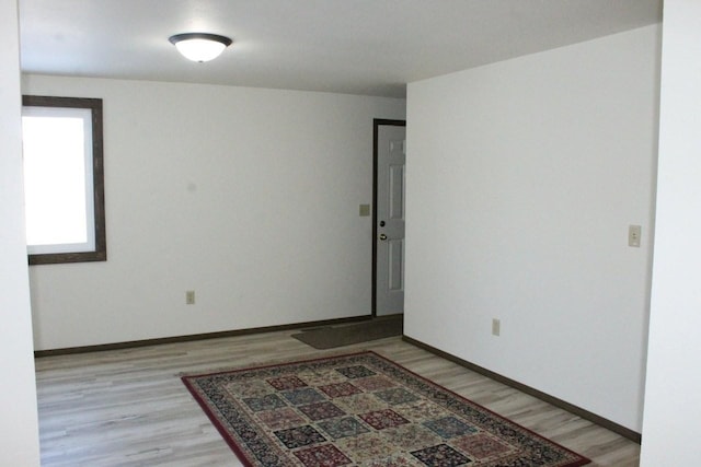 empty room with light wood-type flooring and baseboards