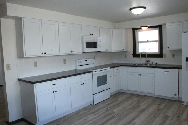 kitchen with white appliances, a sink, and white cabinets