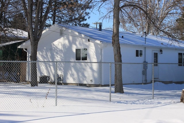 view of snow covered exterior with fence private yard