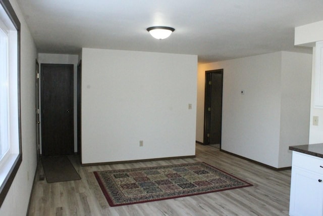 empty room with baseboards and light wood-style floors