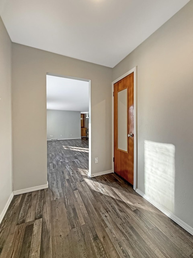 unfurnished room featuring dark wood finished floors and baseboards