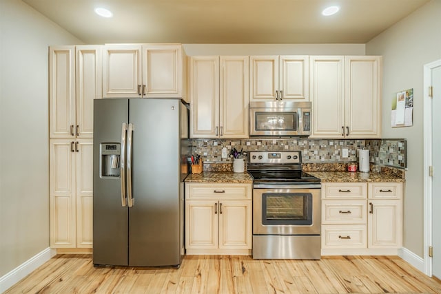 kitchen featuring dark stone counters, stainless steel appliances, and decorative backsplash