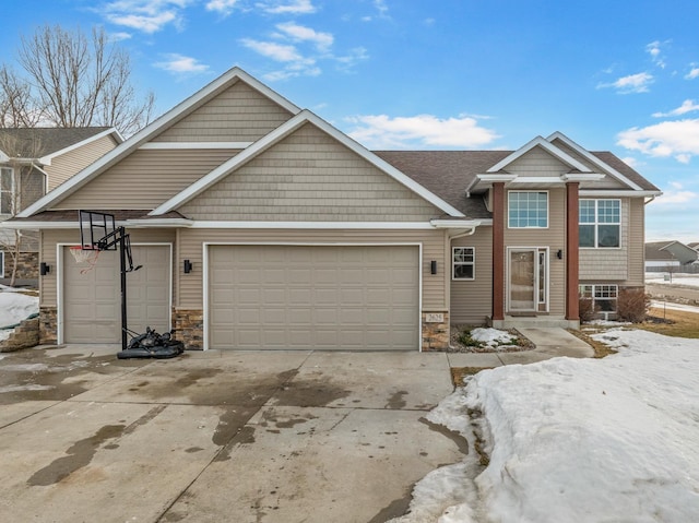 view of front facade featuring stone siding, driveway, and an attached garage