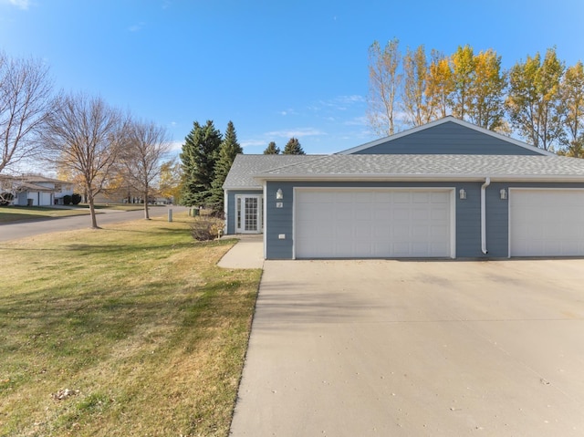 view of front of property with driveway, an attached garage, a front lawn, and a shingled roof