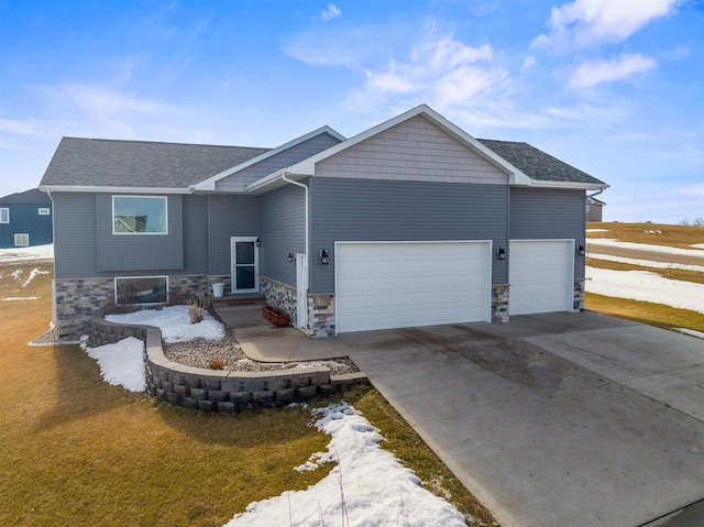 view of front of home featuring a garage, stone siding, a shingled roof, and concrete driveway