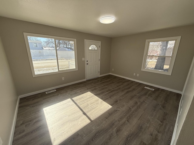 foyer featuring visible vents, baseboards, and dark wood-style flooring