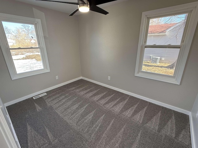 unfurnished room featuring dark colored carpet, visible vents, ceiling fan, and baseboards