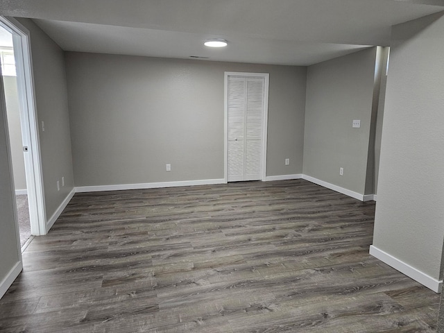 empty room featuring dark wood-style flooring and baseboards