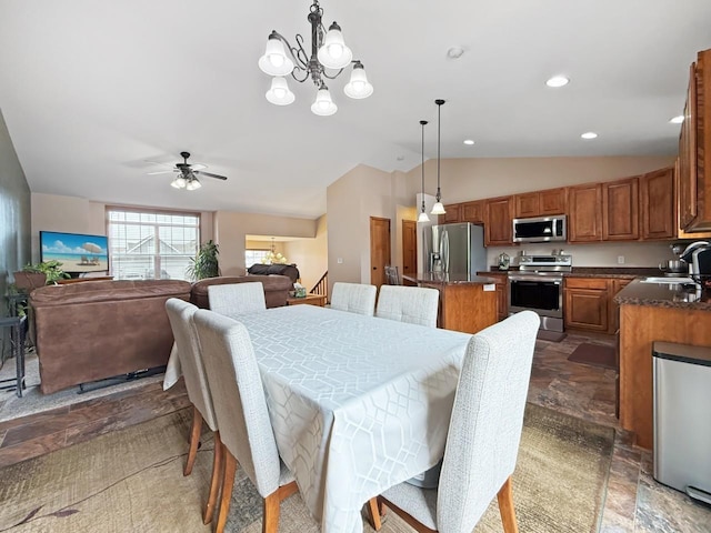 dining room featuring lofted ceiling, stone finish floor, ceiling fan with notable chandelier, and recessed lighting