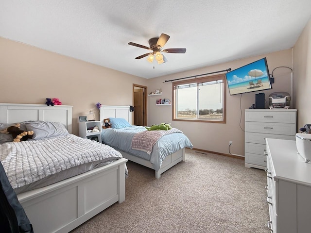 bedroom featuring light carpet, ceiling fan, a textured ceiling, and baseboards