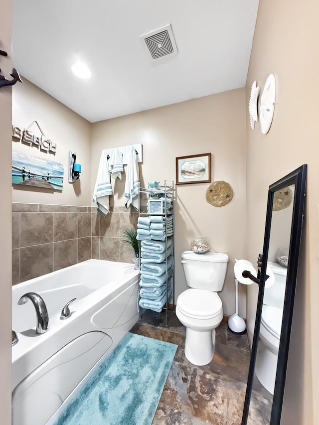 full bath with visible vents, toilet, and a bath