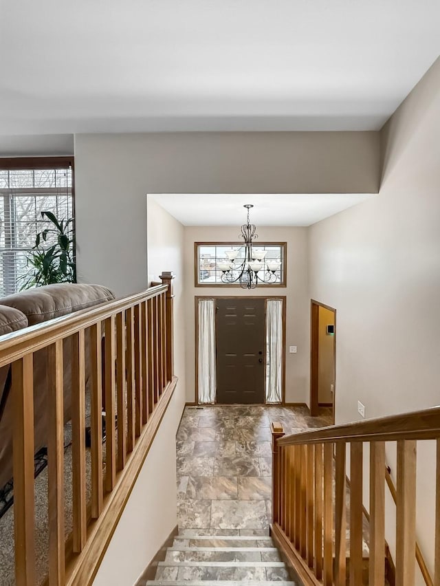 foyer with a chandelier and stone finish flooring