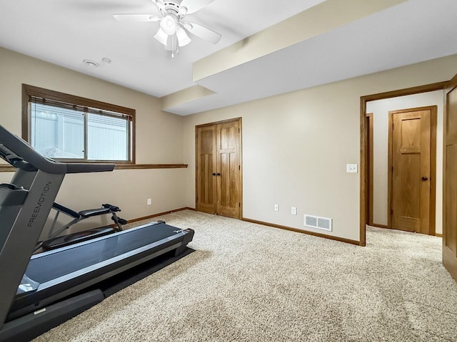 workout room featuring a ceiling fan, light colored carpet, visible vents, and baseboards