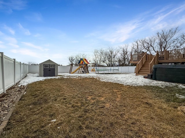 view of yard with an outbuilding, a shed, a playground, and a fenced backyard