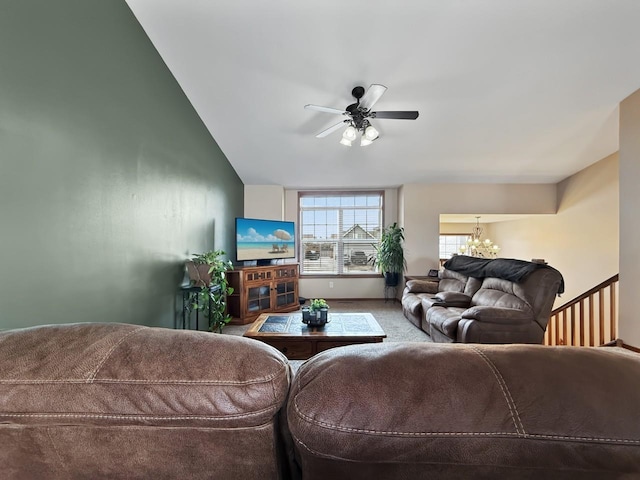 living area with ceiling fan with notable chandelier and carpet floors