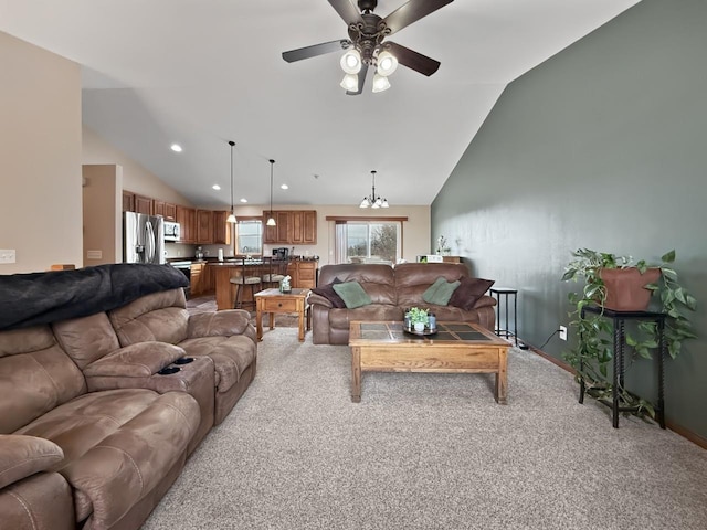 living area with vaulted ceiling, recessed lighting, ceiling fan with notable chandelier, and light colored carpet