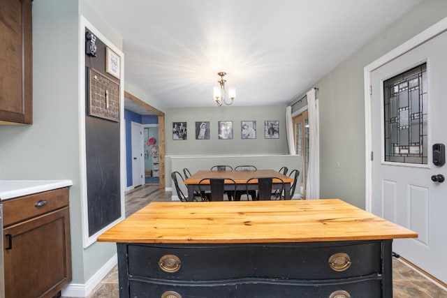 dining area featuring baseboards and an inviting chandelier