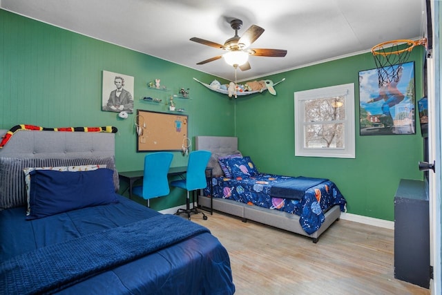 bedroom with ceiling fan, wood finished floors, and baseboards