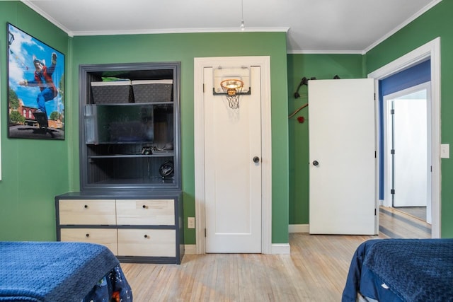 bedroom with baseboards, wood finished floors, and crown molding