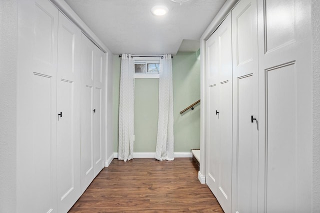 hallway with dark wood finished floors and baseboards