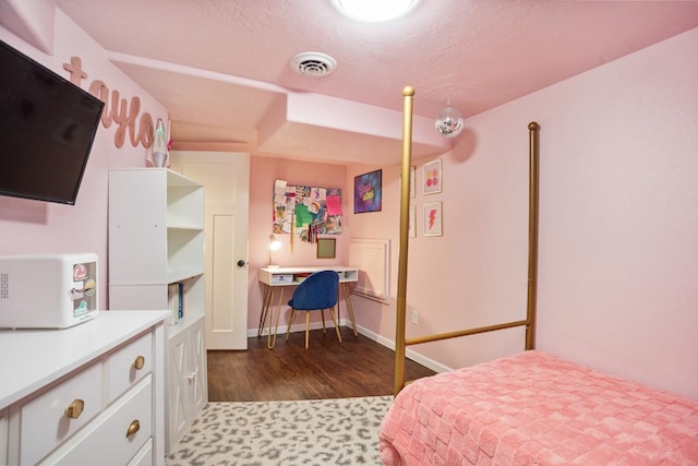 bedroom featuring visible vents, baseboards, and wood finished floors