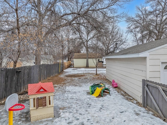 yard layered in snow with fence and an outdoor structure