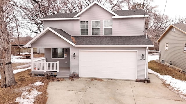 traditional-style home with a garage, driveway, and roof with shingles