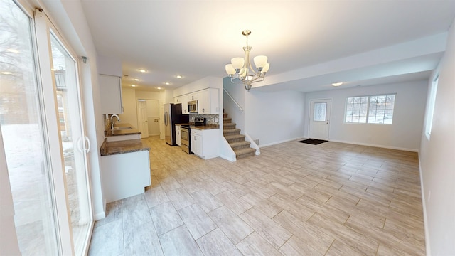 interior space with recessed lighting, a sink, baseboards, stairway, and an inviting chandelier