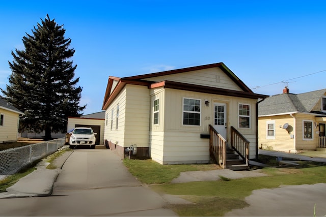 view of front of property with an outbuilding, driveway, fence, and entry steps