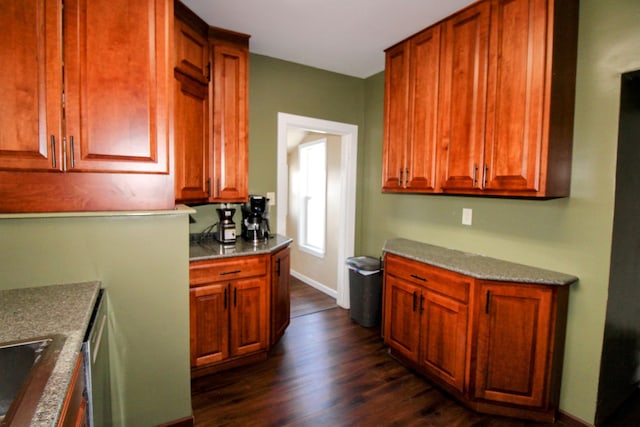 kitchen with dark wood-style flooring, a sink, and baseboards