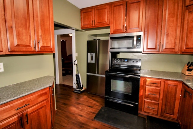 kitchen with appliances with stainless steel finishes and dark wood-type flooring