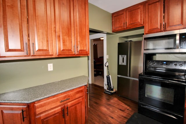 kitchen featuring stainless steel appliances, dark wood-type flooring, and brown cabinetry