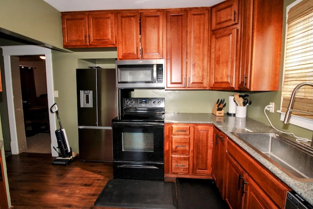 kitchen with stainless steel appliances, dark wood-style flooring, and a sink