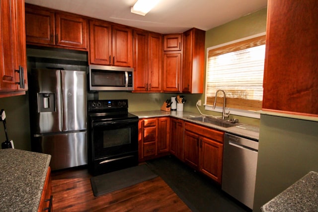 kitchen featuring stainless steel appliances, dark wood finished floors, and a sink